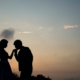 silhouette of man kissing hand of woman