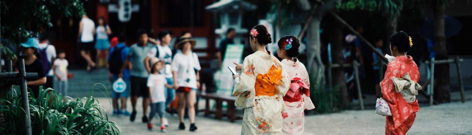 woman in white and red floral kimono walking on street during daytime