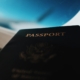 silhouette of passport booklet with airplane window background