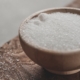 a wooden bowl filled with sugar on top of a wooden table